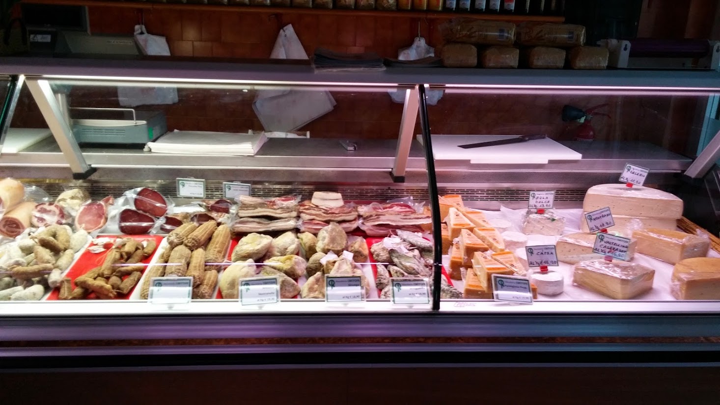 La vetrina della bottega con salumi e formaggi